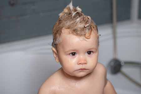 Child bubble bath. Cute baby boy enjoying bath and bathed in the bathroom.の写真素材