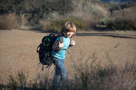 Child boy on camping with backpack hiking. Kid tourist goes on a hikeの写真素材