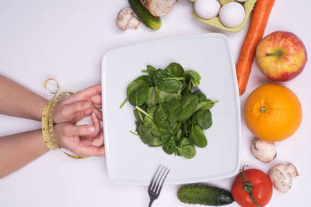 Diet and healthy food concept. Woman hand with measuring tape. Tied female hands with measure.の写真素材