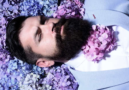 A bearded man with a decorated beard for the Spring holiday. Flower in the beard. Bearded man with beard in flover in beard, bearded gay.の写真素材