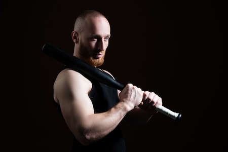 Brutal man with baseball bat for fighting, concept of men power and strong. Dangerous man with serious emotion.の写真素材
