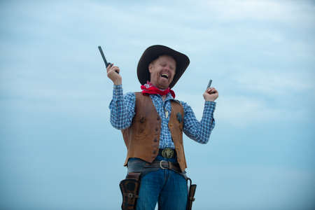 Wanted western. Happy funny cowboy with weapon. American bandit, western man with hat. West and guns.の写真素材