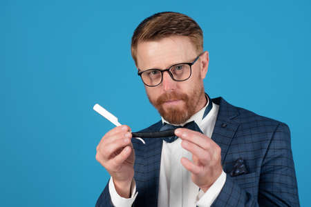 Barber blade. Man with vintage razor. Funny barber isolated on blue.の写真素材