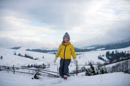 Lovely joyful girl lpaying in the winter forest.の写真素材