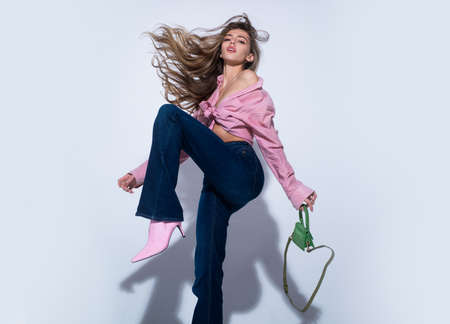 Fashion woman in pink shirt and jeans. Beautiful woman wearing vogue clothes. Fashion photo.の写真素材