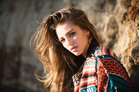 Beautiful woman in boho style sweater. Beautiful young woman in fashion dress outdoor. Sexy and...