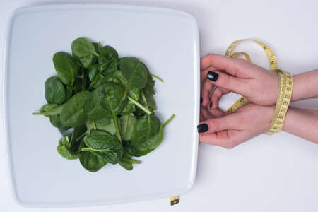 Woman hand with measuring tape. Tied female hands with measure. Diet and healthy food concept,の写真素材