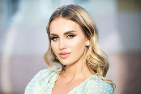 Portrait of young blonde woman outdoor. Romantic girl with beauty face.