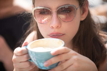 Closeup portrait of woman with cup coffee. Coffee. Beautiful Girl Drinking Tea. Cup of Hot Beverage. Close up woman lip with mouth drink latte.の写真素材