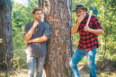 Woodcutters lumberjacks. Hipsters men on serious face with axe. Lumberjack brutal and bearded holds...