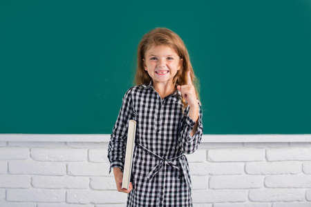 School girl with pointing finger studying math on lesson in classroom at elementary school.の写真素材