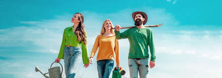 A group of friends enjoy the spring nature and take care of the plants. Nature, environment and ecology concept. Spring friends, banner.の写真素材