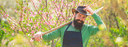Spring banner of man outdoor. Gardener planting in spring garden. Gardener work in yard with garden tools and have good time. Become organic farmer.の写真素材