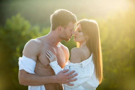 Young couple in love spends time together. Man embracing and going to kiss sensual woman.