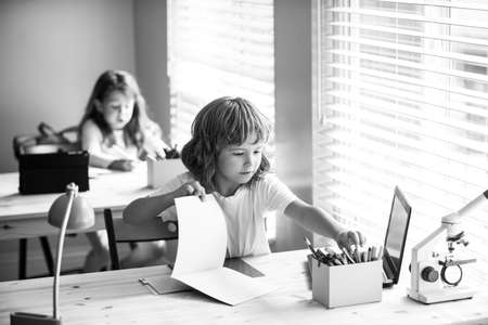 First grade. School boy with writing lesson. Back to school. Happy smiling pupil drawing at the...