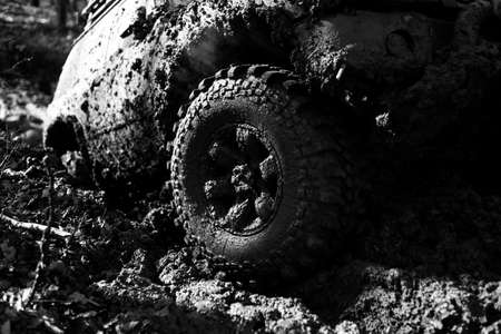 Detailed view of motion the wheels tires and off-road truck shaft that goes in the snow and mud through the wheels on the forest. Travel and racing concept for four wheel drive off road vehicle.の写真素材