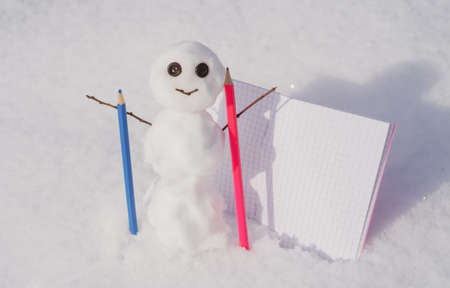 Snow man writer. Blog creation concept with snowman, freelance work business and marketing. Creative online blog image with pencil and empty paper blank.の写真素材