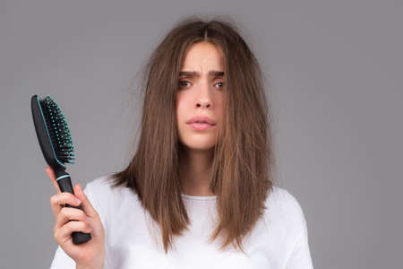 Young woman is very upset because of hair loss. Haircut and healthy haircare. Serious hair loss problem for health care shampoo.の写真素材
