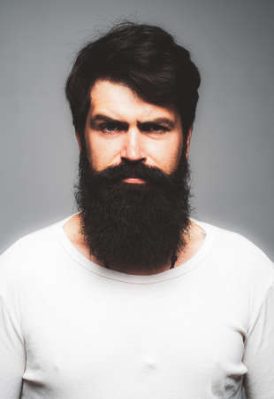 Portrait of confident serious man has beard and mustache, looks seriously, isolated. Thinking stylish bearded guy.の写真素材