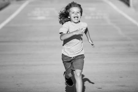 Cheerful boy running to school. Kids run race.の写真素材