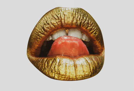 Golden lipstick closeup. Lips with metal makeup. Sexy lips, Metallic lipstick close up. Creative art lipstick.の写真素材