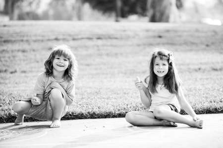 Couple of children playing outdoor. Kids adaptation. Brother sister at summer sunny park.の写真素材