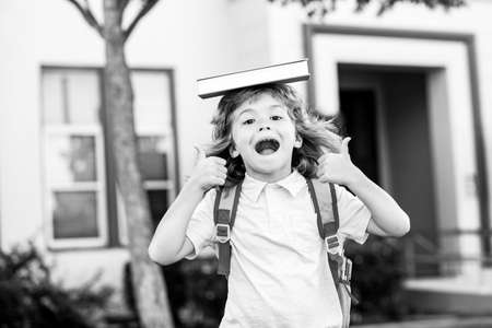 Concept of child education and reading. Cute kids near school outdoors. First day at school.の写真素材