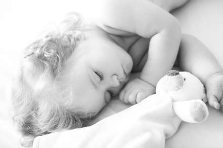 Beautiful cute baby sleeping in bed at home with toy, child sleeping in the bed.の写真素材