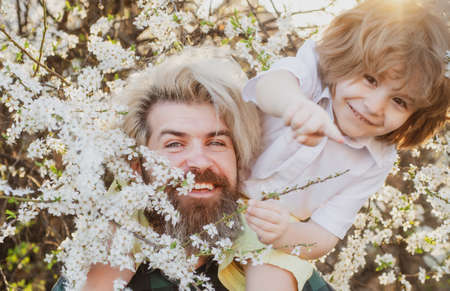Family relationships and problems. Child with dad in summer park. Shoulder ride.の写真素材