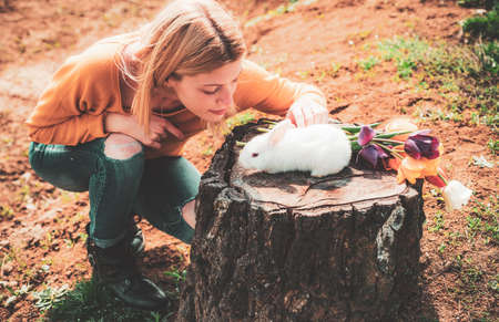 Funny Easter rabbit. Little girl having fun on Easter egg hunt. Happy smiling little teen girl with bunny hunting easter eggs.の写真素材