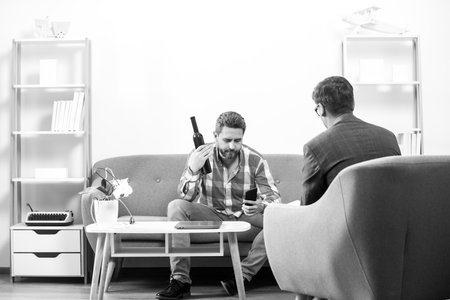 Man discussing his psychological problems with a psychiatrist during a therapy session. Social...