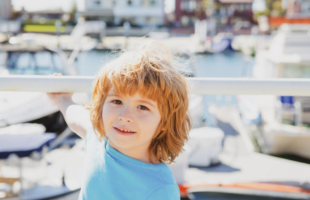 Berth near sea. Little boy in yacht port. Summer vacation. Traveling by ferry. Sea coast.の写真素材