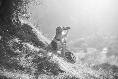 Woman traveler looking at Batur volcano. Indonesia. Female hiker with backpack at mountain. Girl hiking a hill at panoramic point. Backpacking tourism concept.の写真素材