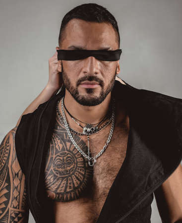 Confident attractive man with ribbon on eyes with rope. Trust concept. Muscular macho man with athletic body.の写真素材