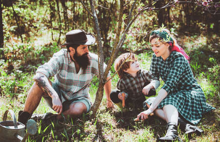 Happy family Farmers working with spud on spring field. I love our moments in the countryside. Young family gardening in the garden.の写真素材