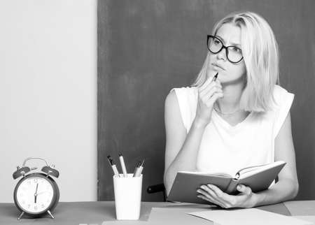 The teacher thinking in the classroom on blackboard background. Serious idea. Teaching and people learning concept.の写真素材