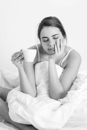 Woman with morning coffee on the bed.の写真素材