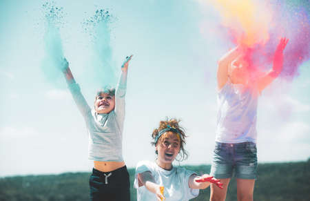 Excited children painted in the colors of Holi festival. Kids splashing colorful paint.