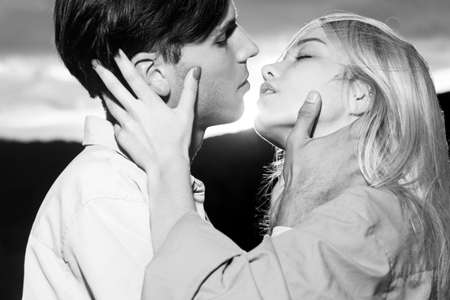 Young couple in love spends time together. Embraces of a loving couple on sunset. Man embracing and...