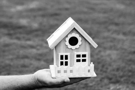 Male hands holding small miniature toy house. Mortgage property insurance dream moving home and real...