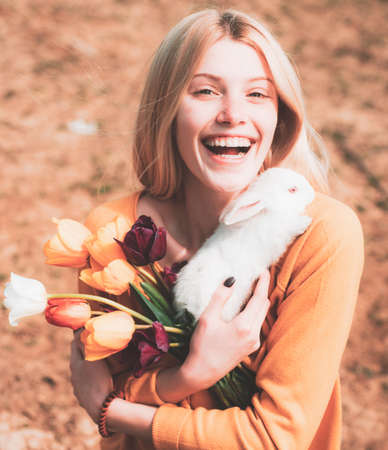 Lovely woman hold white rabbit. Portrait of young woman posing with rabbit. Happy easter.