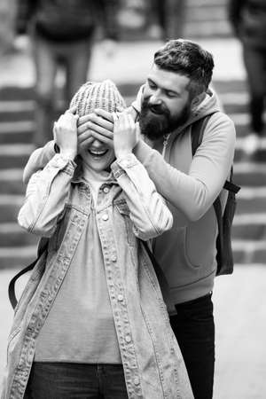 Happy man closing eyes of lady with attractive smile with handsの写真素材