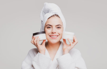 Beautiful smiling girl with clean skin proposing a cosmetics product. Gestures for advertisement.の写真素材