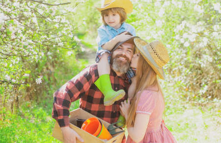 Family gardener on walk in garden or park. Parenthood together leisure concept.