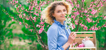 Cute female farmer working on spring field. Spring woman on Background with flowers on a spring day. Banner spring design, advertising for website header.の写真素材