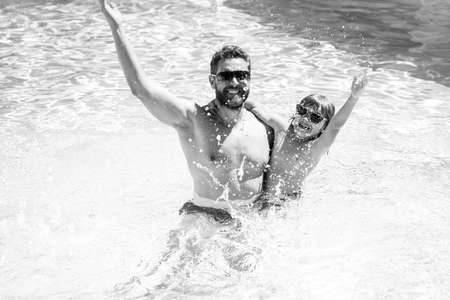 Father and son swimming in pool, summer family. Active weekend.