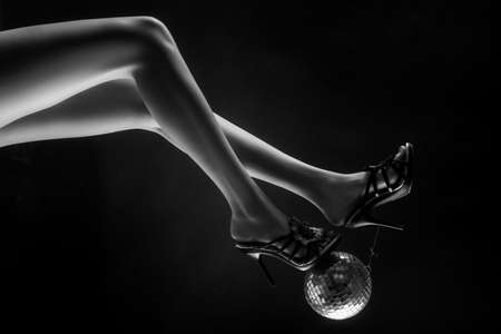 Celebrate concept. Heels with gold ball. Disco and party legs. Party time.の写真素材