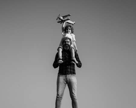 Father and son happy family. Boy sitting on fathers shoulders.の写真素材
