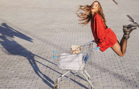 Marketing concept. Online shopping. Woman with shop cart.の写真素材