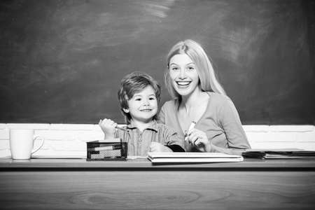 Smiling young teacher and little student school boy in a classroom.の写真素材